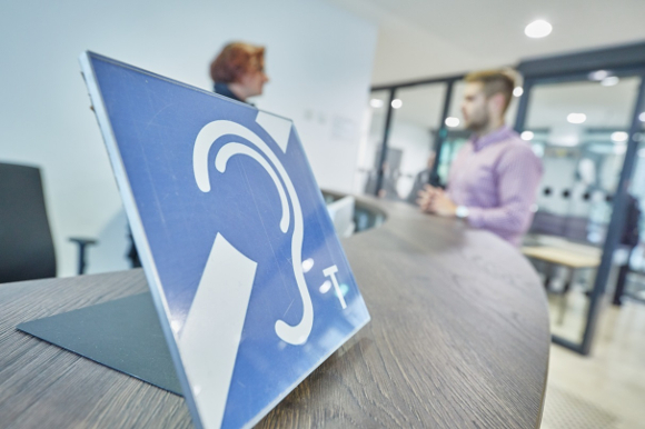 Foto zu Auskunftstresen mit blauem Symbol und zusätzlichem Hörer