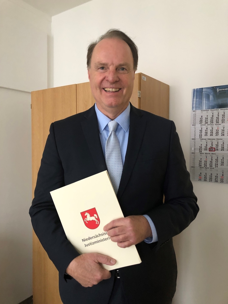 Der neue Vorsitzende Richter am Finanzgericht Volker Kreft hält seine Ernennungsurkunde in Händen